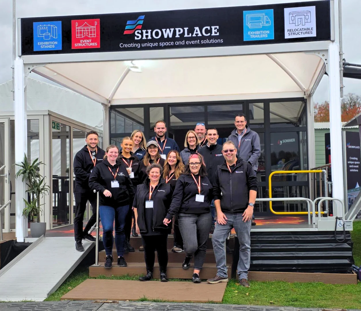 The Showplace team standing in front of a branded event structure.