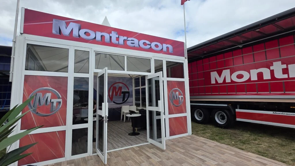 Montracon exhibition stand with a branded trailer parked alongside.