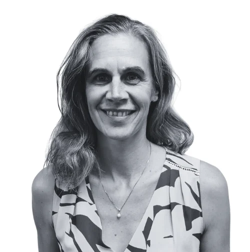 Renata smiling in a black and white headshot wearing a patterned top and a necklace.